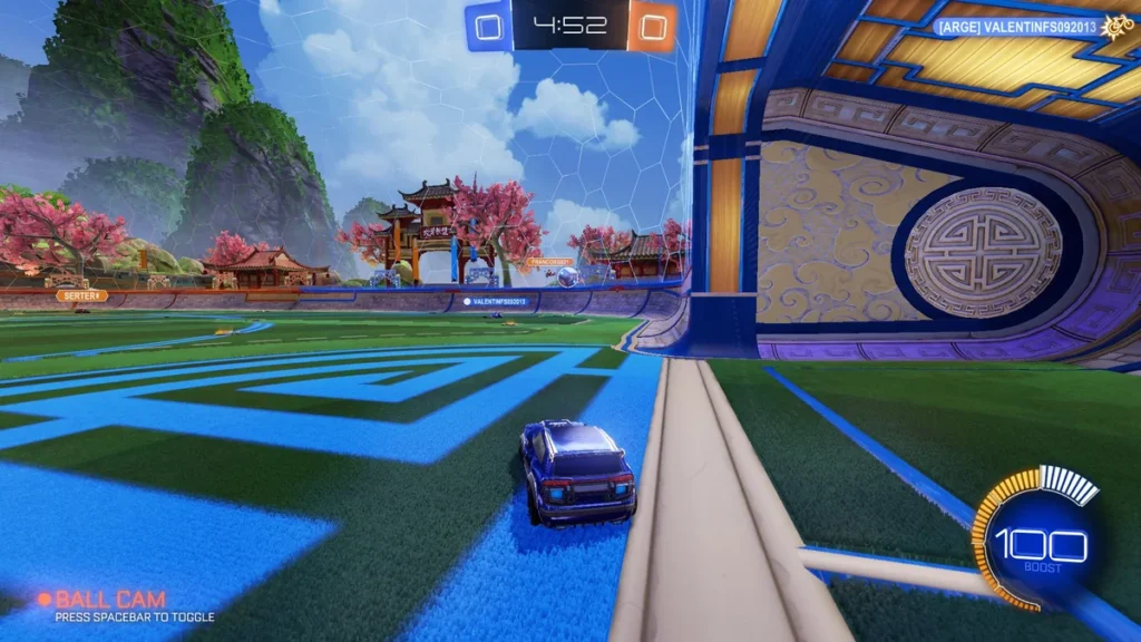 Guia de Rocket League 2v2: táticas essenciais, jogadas em dupla e como confiar no parceiro 1 Partida de Rocket League no modo 2v2 com carro azul defendendo o gol em arena temática chinesa